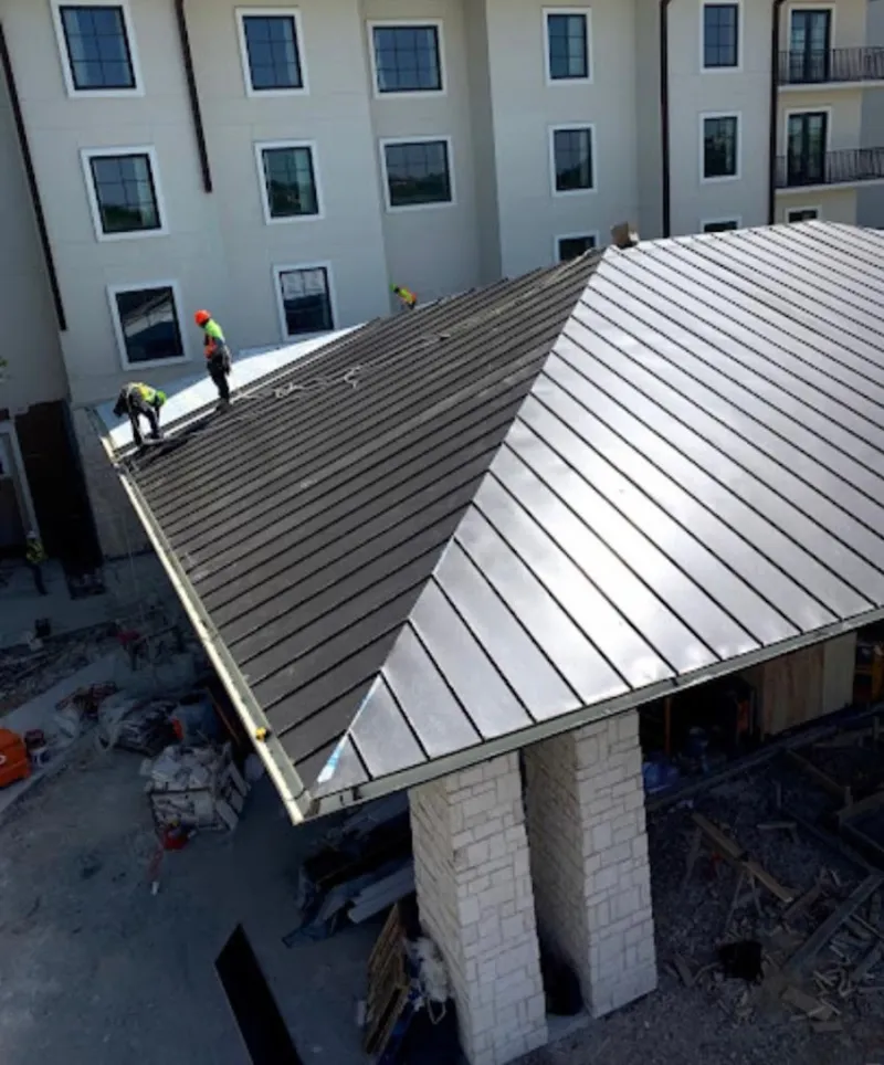 Crew installing standing seam metal roof panels on a commercial project in South San Jose Hills